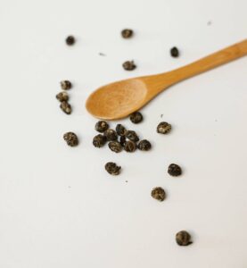 Pepper corns and a wooden spoon.