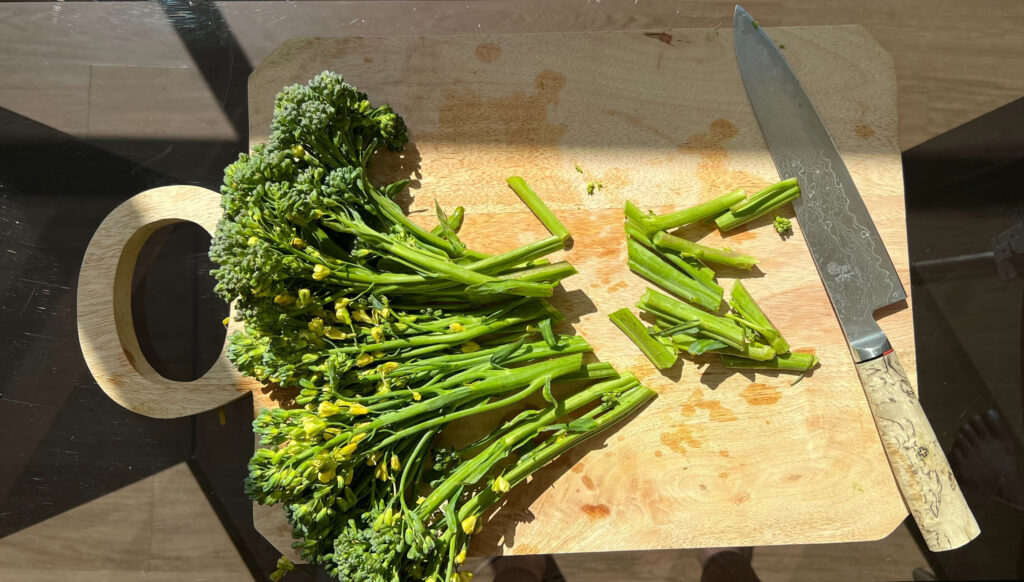 Chopped broccolini on a cutting board.
