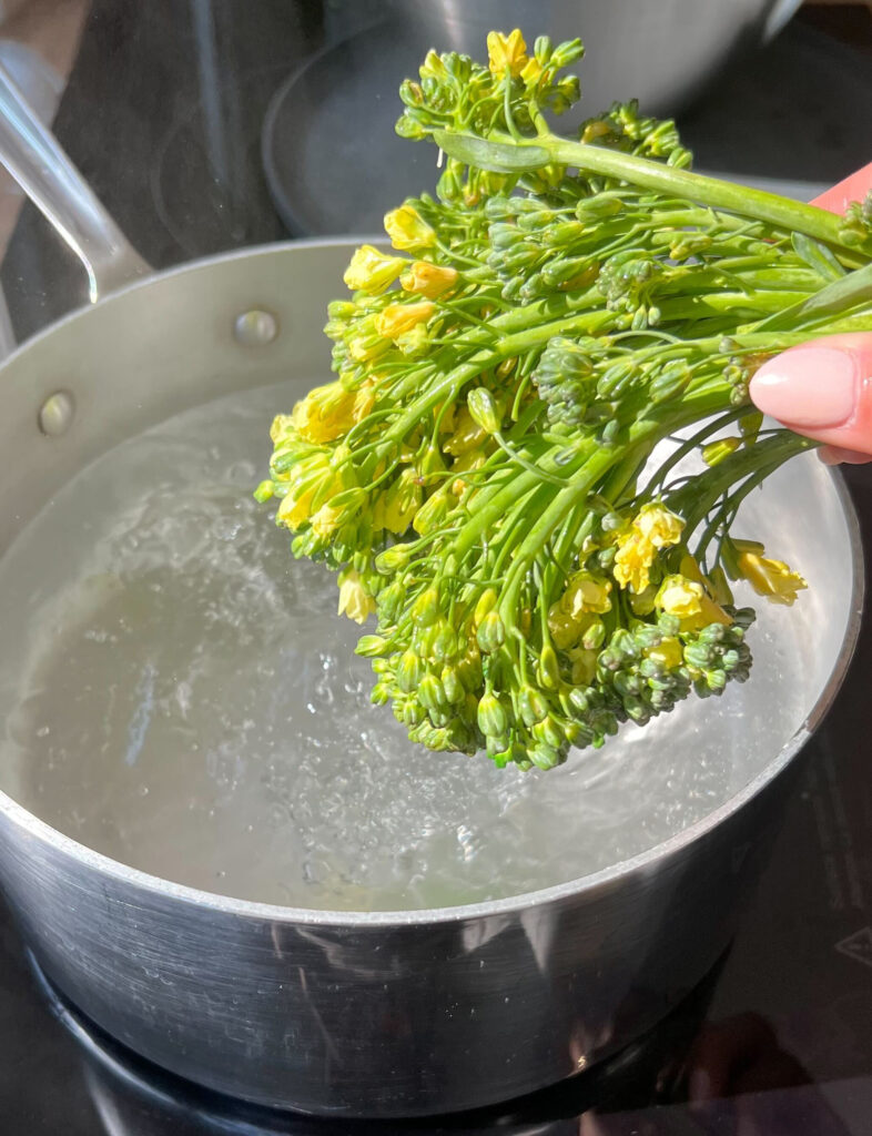 Blanching broccolini in boiling water.