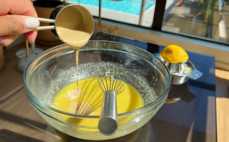 Pouring tahini in a bowl while making the liquid gold dressing.